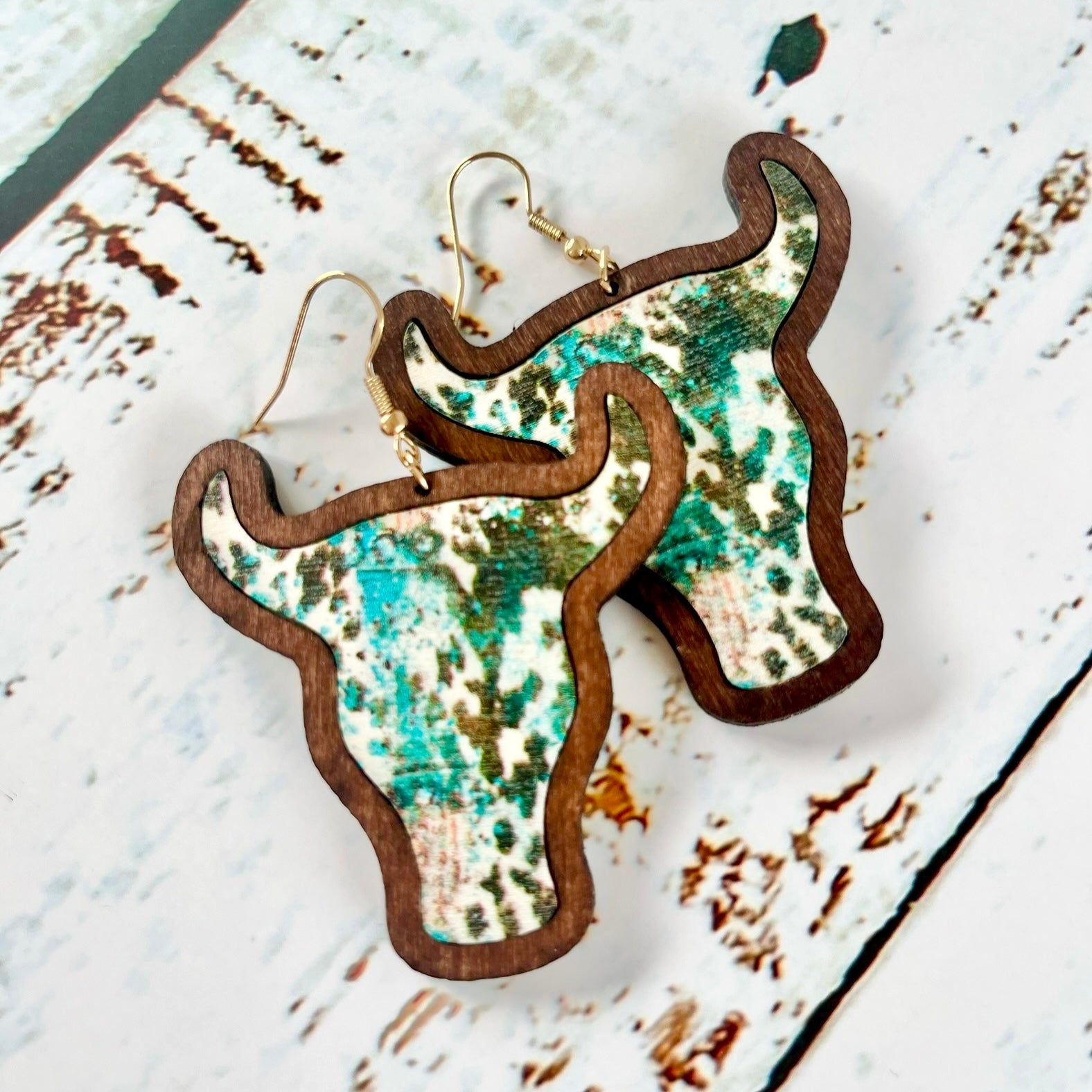 "Wooden cow head earrings with bold Aztec print design and minimalist version, perfect for boho and rustic style lovers."
