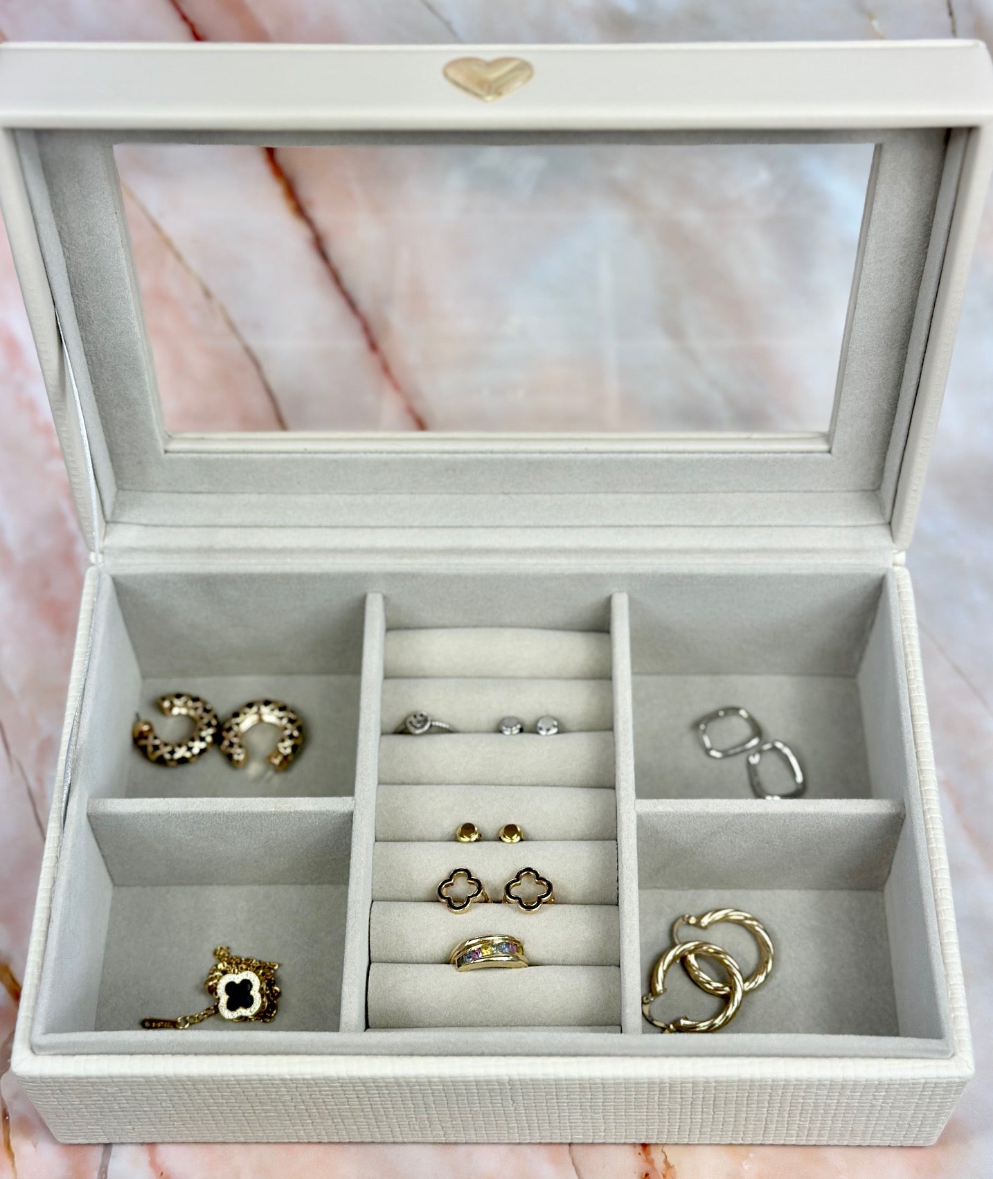 Elegant jewelry boxes in pink, cream, and large designs with compartments, mirrors, and gold heart accents, perfect for storing rings and jewelry."