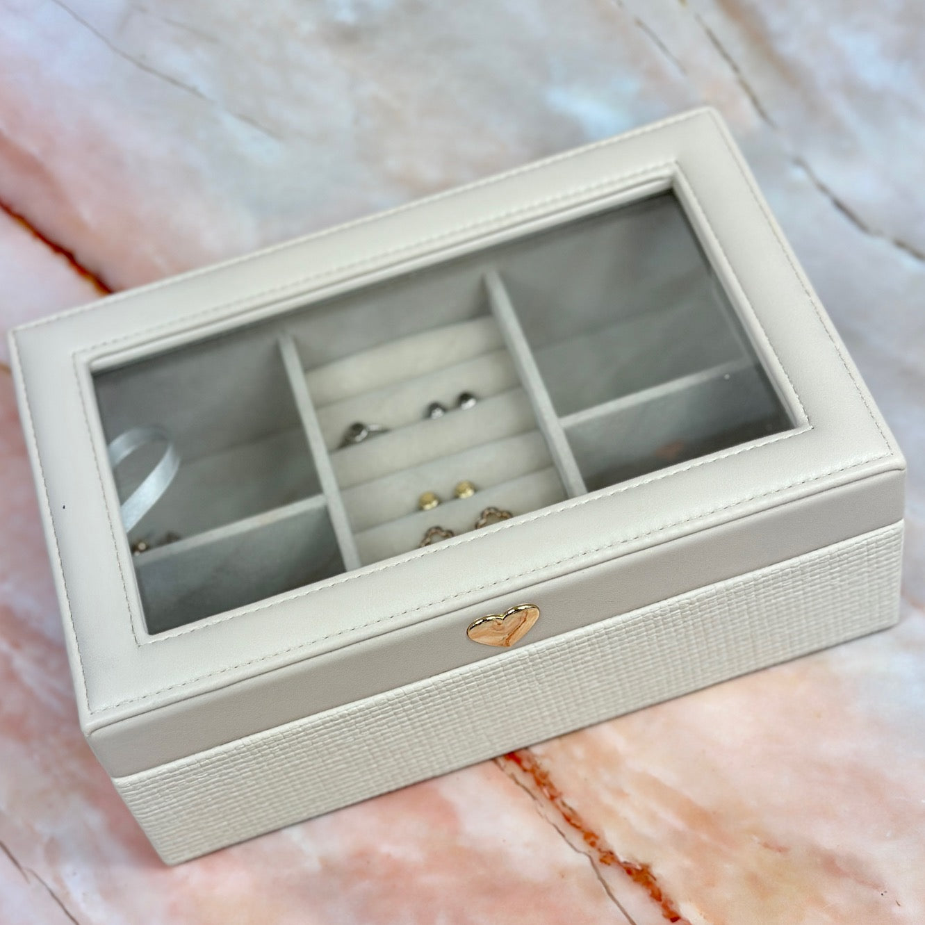 Elegant jewelry boxes in pink, cream, and large designs with compartments, mirrors, and gold heart accents, perfect for storing rings and jewelry."
