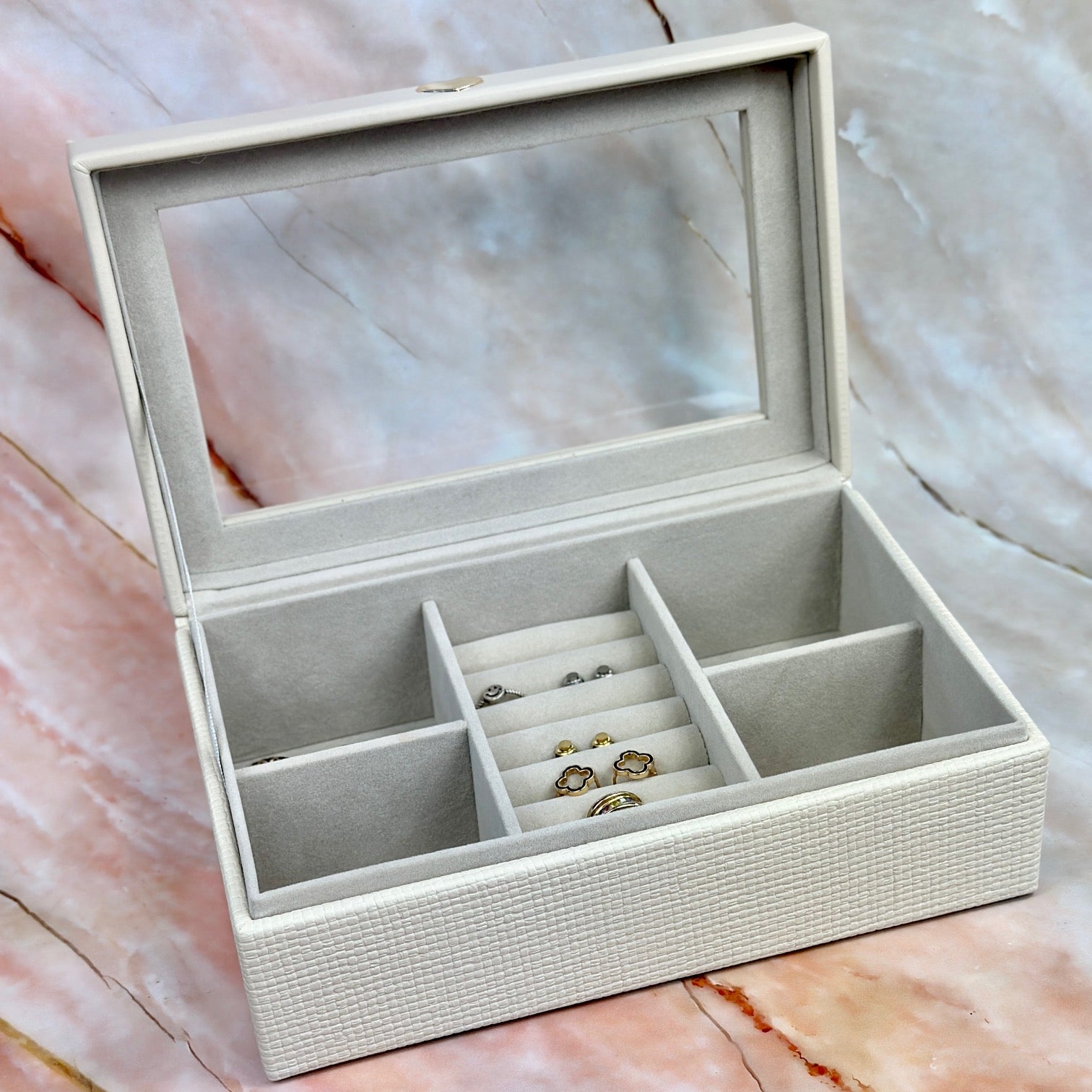 Elegant jewelry boxes in pink, cream, and large designs with compartments, mirrors, and gold heart accents, perfect for storing rings and jewelry."