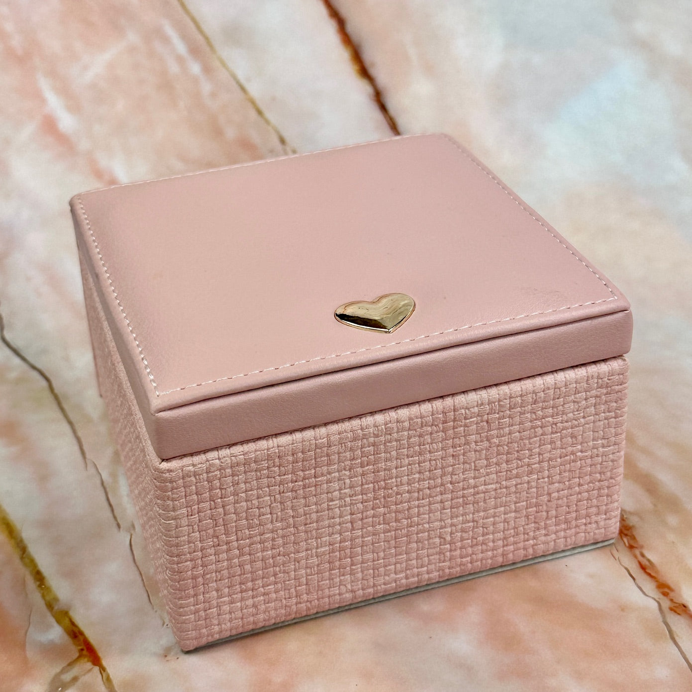 Elegant jewelry boxes in pink, cream, and large designs with compartments, mirrors, and gold heart accents, perfect for storing rings and jewelry."