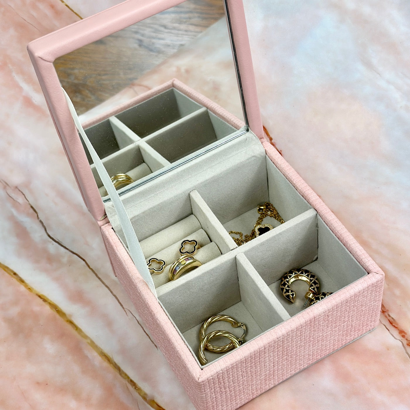 Elegant jewelry boxes in pink, cream, and large designs with compartments, mirrors, and gold heart accents, perfect for storing rings and jewelry."