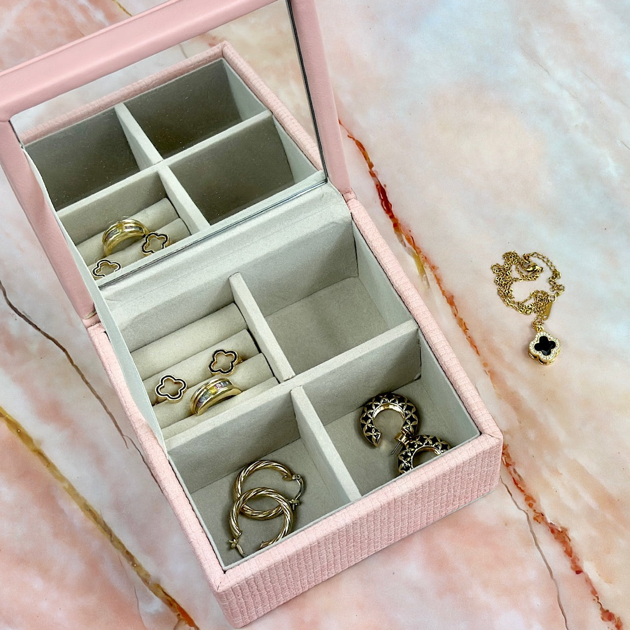 Elegant jewelry boxes in pink, cream, and large designs with compartments, mirrors, and gold heart accents, perfect for storing rings and jewelry."